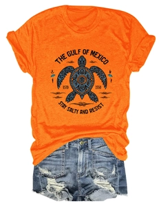 Détail d'un t-shirt orange avec imprimé tortue et d'un short en jean effet usé