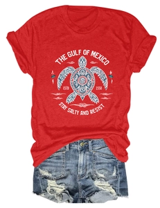 Détail d'un t-shirt rouge à manches courtes avec imprimé tortue blanche et short en jean