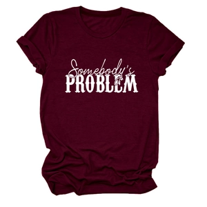 Détail du t-shirt bordeaux montrant l'imprimé blanc Somebody's Problem sur le tissu coton