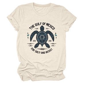 Détail de l'imprimé tortue bleue sur t-shirt beige avec texte The Gulf of Mexico