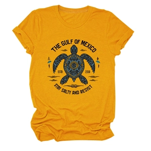 Détail d'un t-shirt moutarde avec imprimé tortue de mer tribale bleue et col rond classique