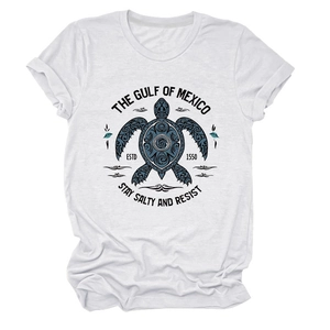 Détail d'un t-shirt en coton blanc avec un imprimé de tortue de mer bleu marine tribal