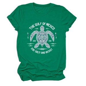 Détail de l'imprimé tortue de mer blanche sur un t-shirt vert à manches courtes