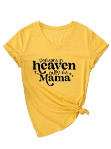 Dettaglio della maglietta gialla con scollo a V e stampa someone in heaven calls me Mama