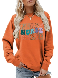 Close-up of bright orange crewneck sweatshirt featuring colorful NURSE graphic print