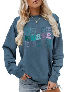 Detail of artistic wavy Nurse lettering on a blue crewneck long-sleeved sweatshirt