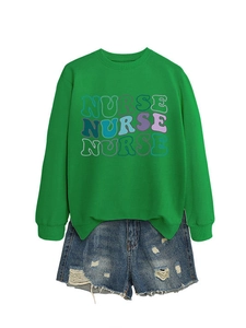 Detail of green nurse sweatshirt with artistic print paired with ripped denim shorts