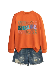 Close-up of bright orange crewneck sweatshirt with colorful NURSE letter print design