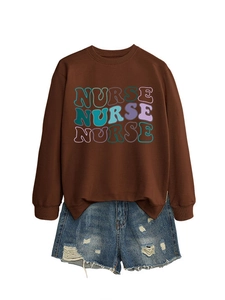 Close-up of brown nurse sweatshirt with wavy print paired with distressed denim shorts