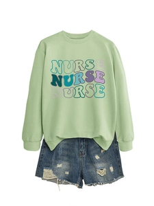 Detail of light green sweatshirt with colorful NURSE typography and ripped denim shorts