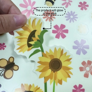 Luminous sunflower and bee wall decals being peeled off for easy application