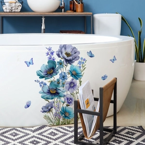 Stickers muraux fleurs et papillons bleus sur une baignoire moderne et élégante