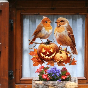 Detail of fall window clings with birds, pumpkins and maple leaves on a glass window