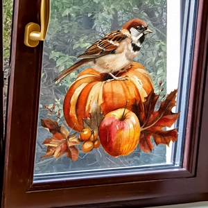 Detail of autumn window sticker featuring a sparrow on a pumpkin with maple leaves