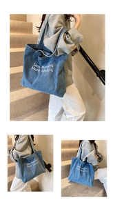 Detail of blue denim tote bag with white 'Less Mondays More Sundays' embroidery