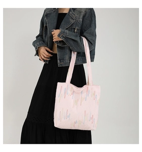 Detail of pink tote bag with colorful wavy embroidery on canvas fabric and shoulder strap