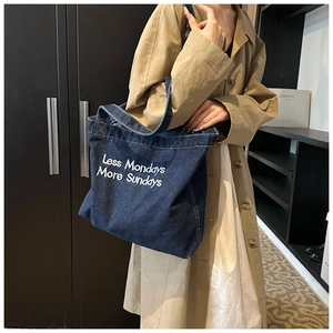 Gros plan sur le sac cabas en jean bleu vintage avec broderie Less Mondays More Sundays