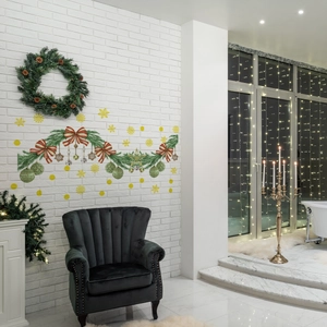 Christmas wall decal with pine branches, red bows and a festive pinecone wreath on white brick