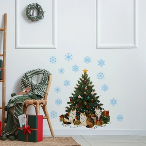 Detail of Christmas wall stickers featuring festive cats, a tree, and blue snowflakes on white wall