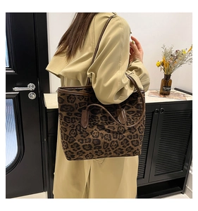 Detail of large leopard print tote bag with brown handles on a shoulder for daily commute