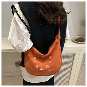 Detail of orange corduroy crossbody bag featuring white fashion letter embroidery