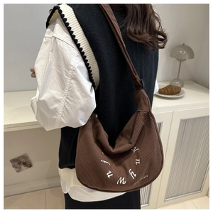 Vue détaillée du sac cabas en velours côtelé marron foncé avec broderie blanche ronde
