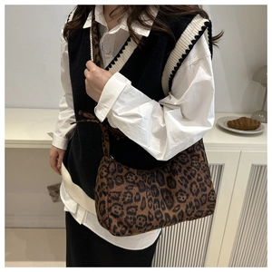 Detailed close-up of the leopard print shoulder bag with soft fabric texture and wide strap
