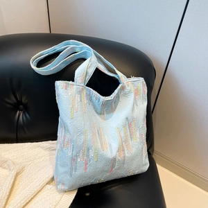 Light blue jacquard tote bag with colorful embroidery and dual handles for daily commute