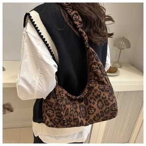 Leopard print hobo bag with ruched shoulder strap shown on model in cozy autumn outfit