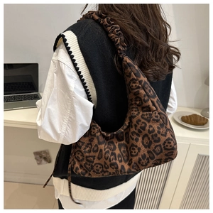 Detail view of leopard print shoulder bag with stylish ruched strap on a model shoulder