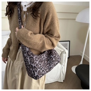 Detail of trendy leopard print hobo shoulder bag styled with modern interior background