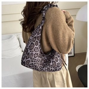 Leopard print hobo bag featuring a trendy scrunchie shoulder strap on model