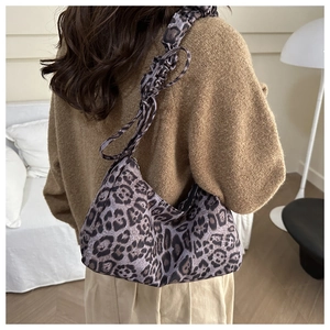 Detail showing leopard print texture and ruffled strap of the shoulder tote bag