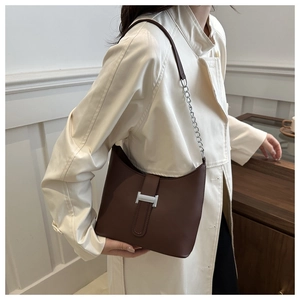 Chic dark brown leather underarm bag with silver H-buckle and chain strap on model