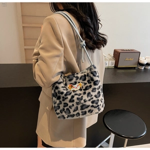 Detail of plush leopard print shoulder bag featuring a cute dog patch and knotted blue strap