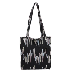 Chic black tote bag featuring colorful zigzag embroidery and large capacity shoulder straps