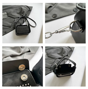 Detail view of black mini crossbody bag with silver studs and metal chain strap
