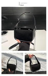 Detail of black crossbody bag with rhinestone texture, wide strap, and silver chain strap