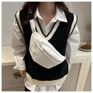Macro detail of white checkered chest bag featuring dual zippers and adjustable nylon strap
