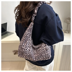 Detailed side view of hobo bag featuring leopard print and scrunchie shoulder strap