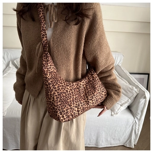 Detail of leopard print hobo bag with dense animal pattern and slouchy shoulder strap