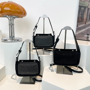Three black chic crossbody bags with silver rhinestones on geometric display stands