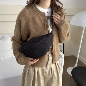 Minimalist black nylon half-moon crossbody bag with adjustable strap and matte finish