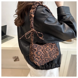 Dettaglio della borsa sottobraccio leopardata con tracolla scrunchie e fiocco decorativo