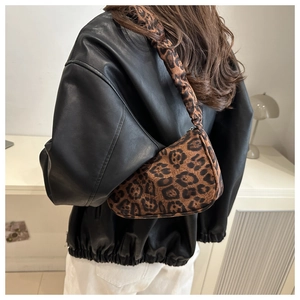 Dettaglio della borsa hobo leopardata con tracolla arricciata indossata da una modella
