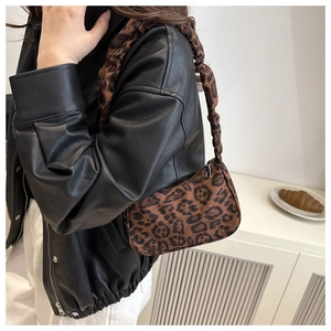 Modella che indossa una borsa leopardata vintage con spalline a pieghe in uno scatto