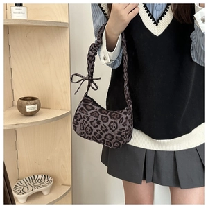 Dettaglio della borsa hobo leopardata con trama del tessuto e fiocco sulla tracolla a pieghe