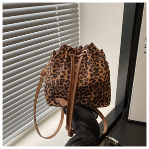 Detail of leopard print bucket bag featuring brown leather drawstring and gold hardware