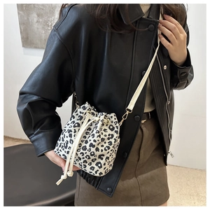 Detail of leopard print bucket bag with drawstring closure and slim shoulder strap