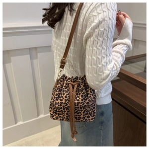 Detail shot of leopard print bucket bag with brown drawstring and adjustable strap
